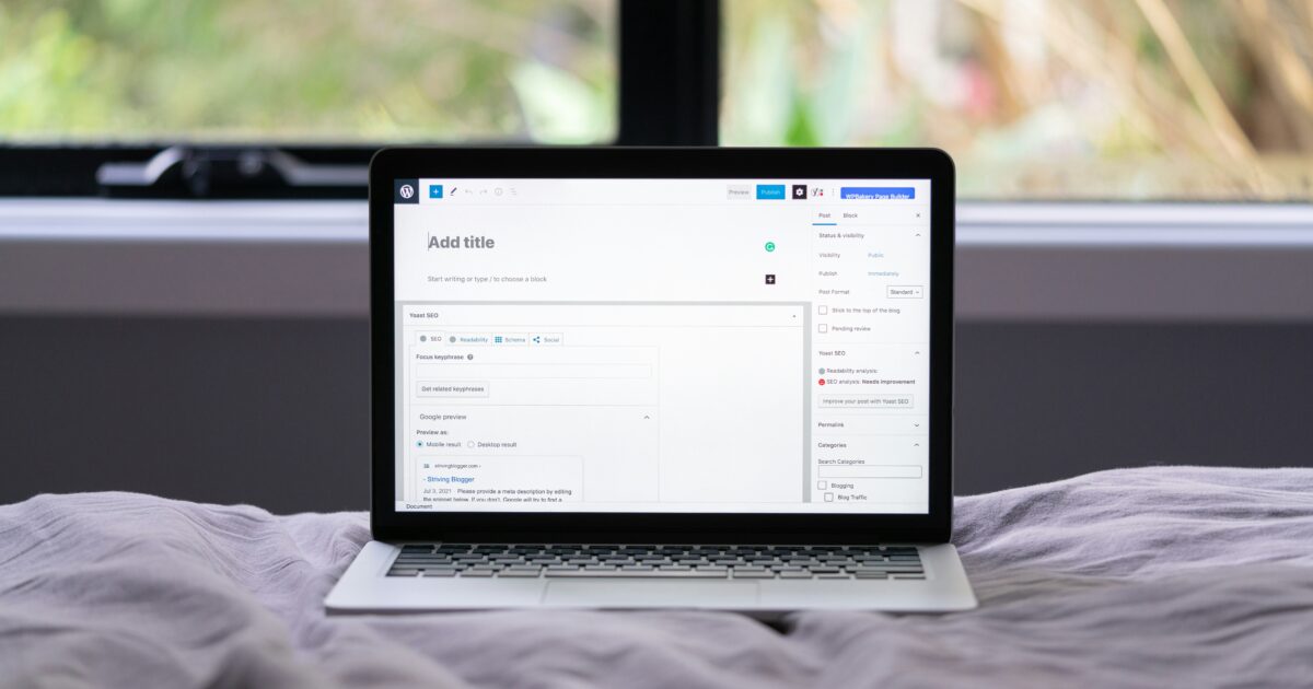 ベッドの上に置かれたノートパソコンでWordPressの投稿作成画面を表示している様子