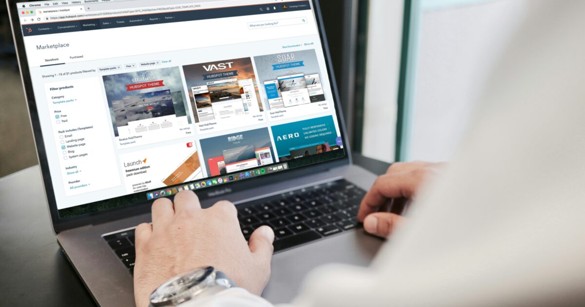 ノートパソコンでWebサイトテンプレートを閲覧しているビジネスパーソンの手元