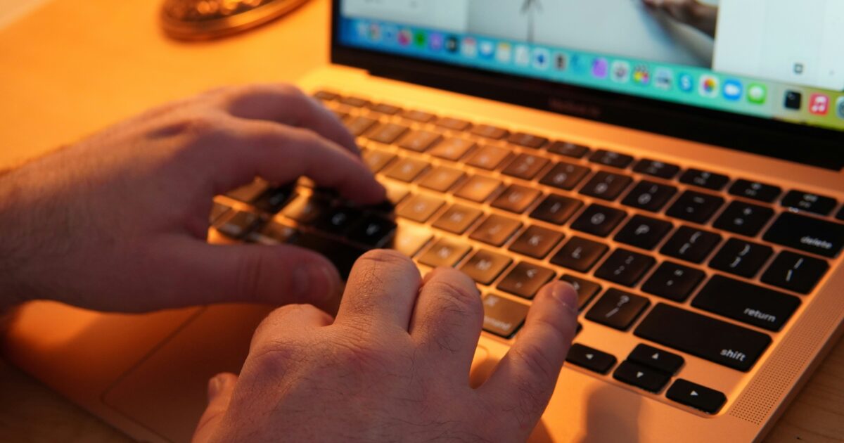 ノートパソコンでプレゼンテーション資料を作成する男性の手元のクローズアップ