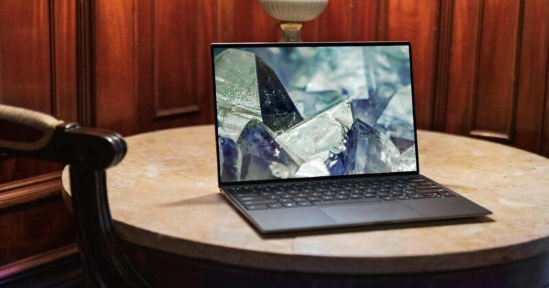 丸テーブルの上に置かれたノートパソコンに結晶の壁紙が表示されている様子
